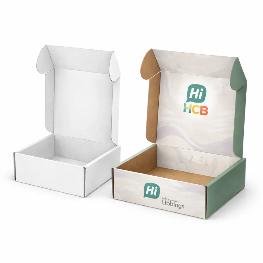 Two open corrugated mailer boxes- one plain white and one featuring a green interior- class=